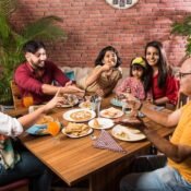 indian-family-eating-food-dining-table-home-restaurant-having-meal-together_466689-12715